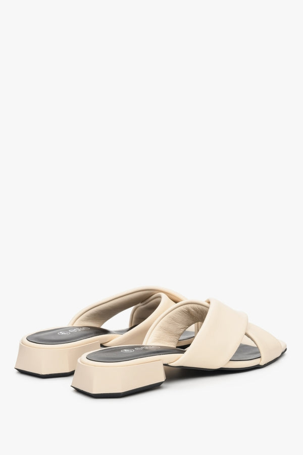 Women's low-heeled leather mules in beige - close-up on back tip of the shoe.