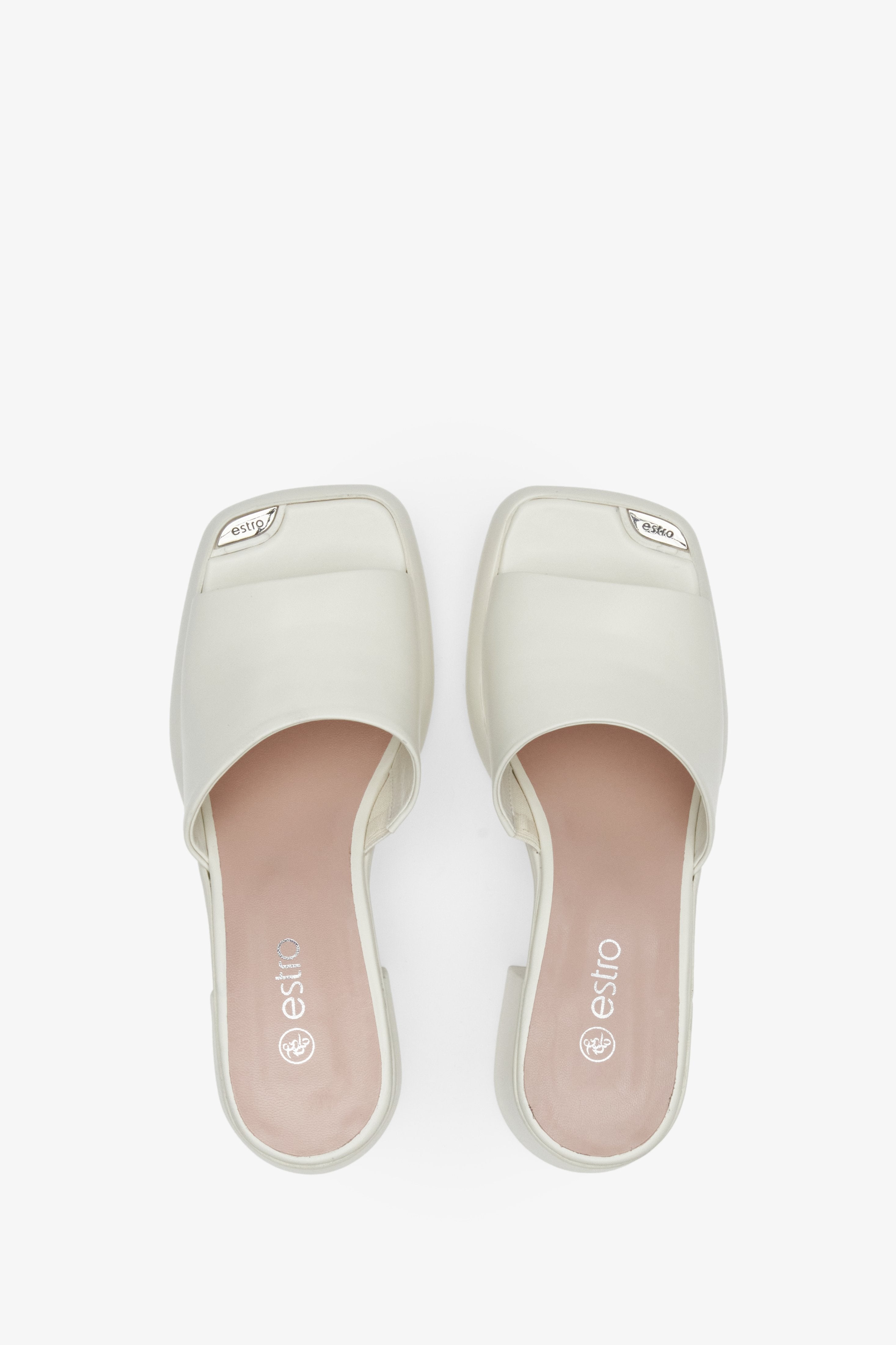 Women's mules in white color with block heels - presentation of footwear from above.