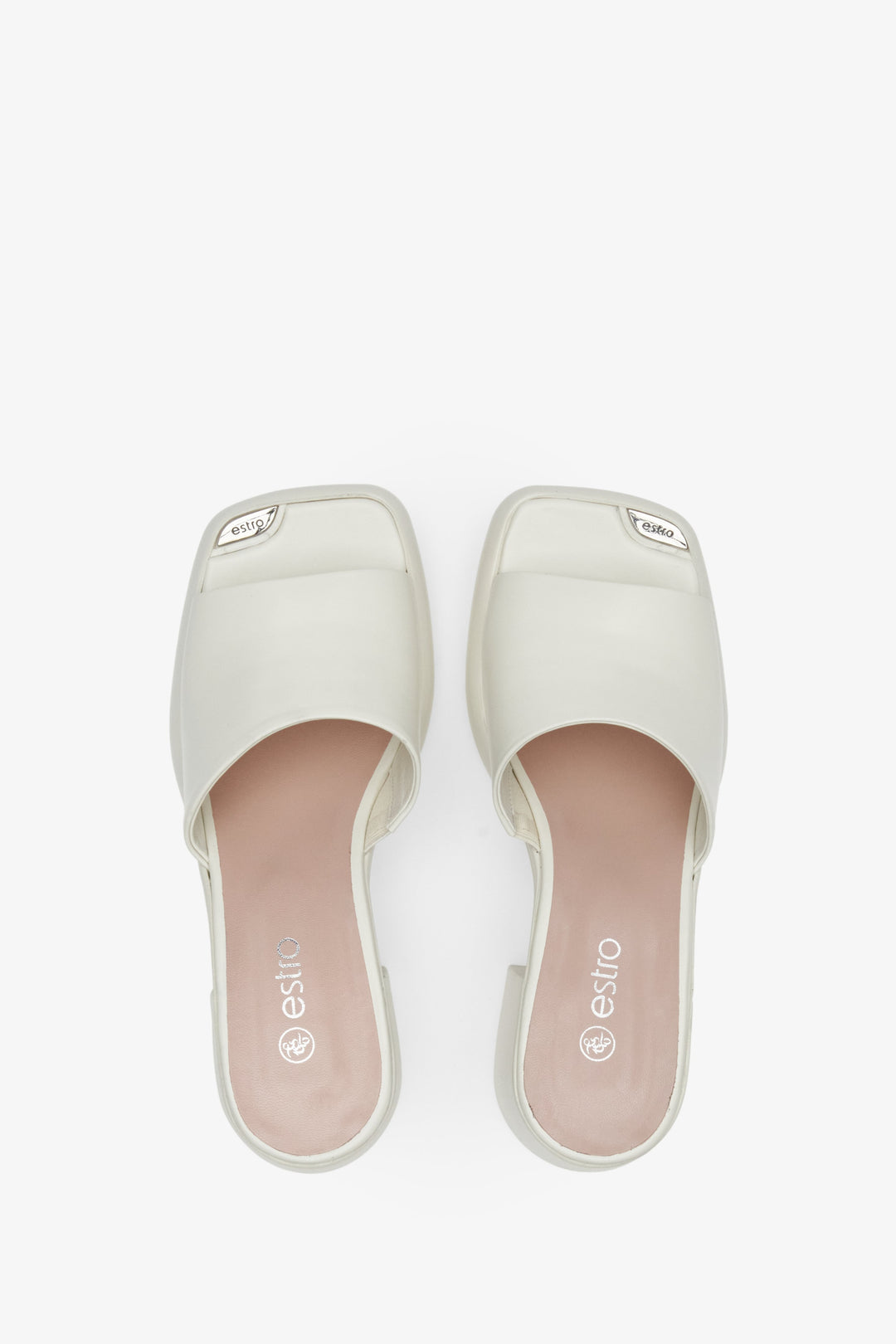 Women's mules in white color with block heels - presentation of footwear from above.