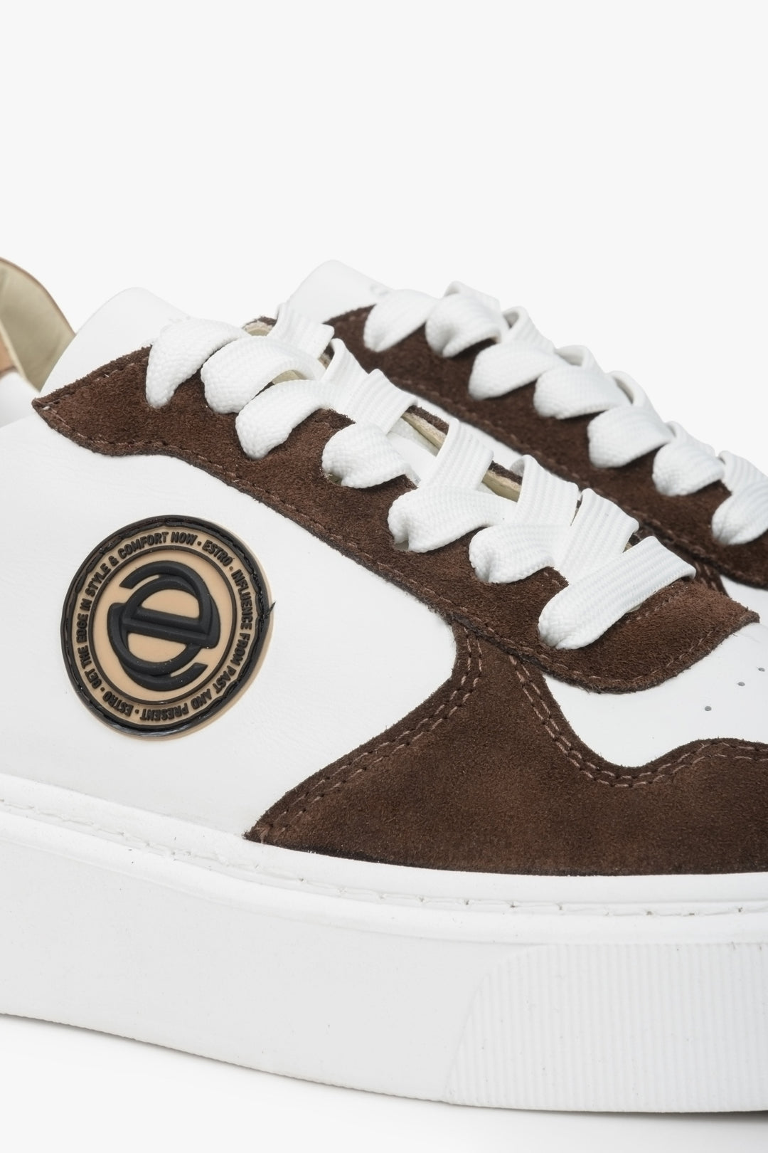 Estro velour and leather sneakers in white and brown. Close-up of decorative logo.