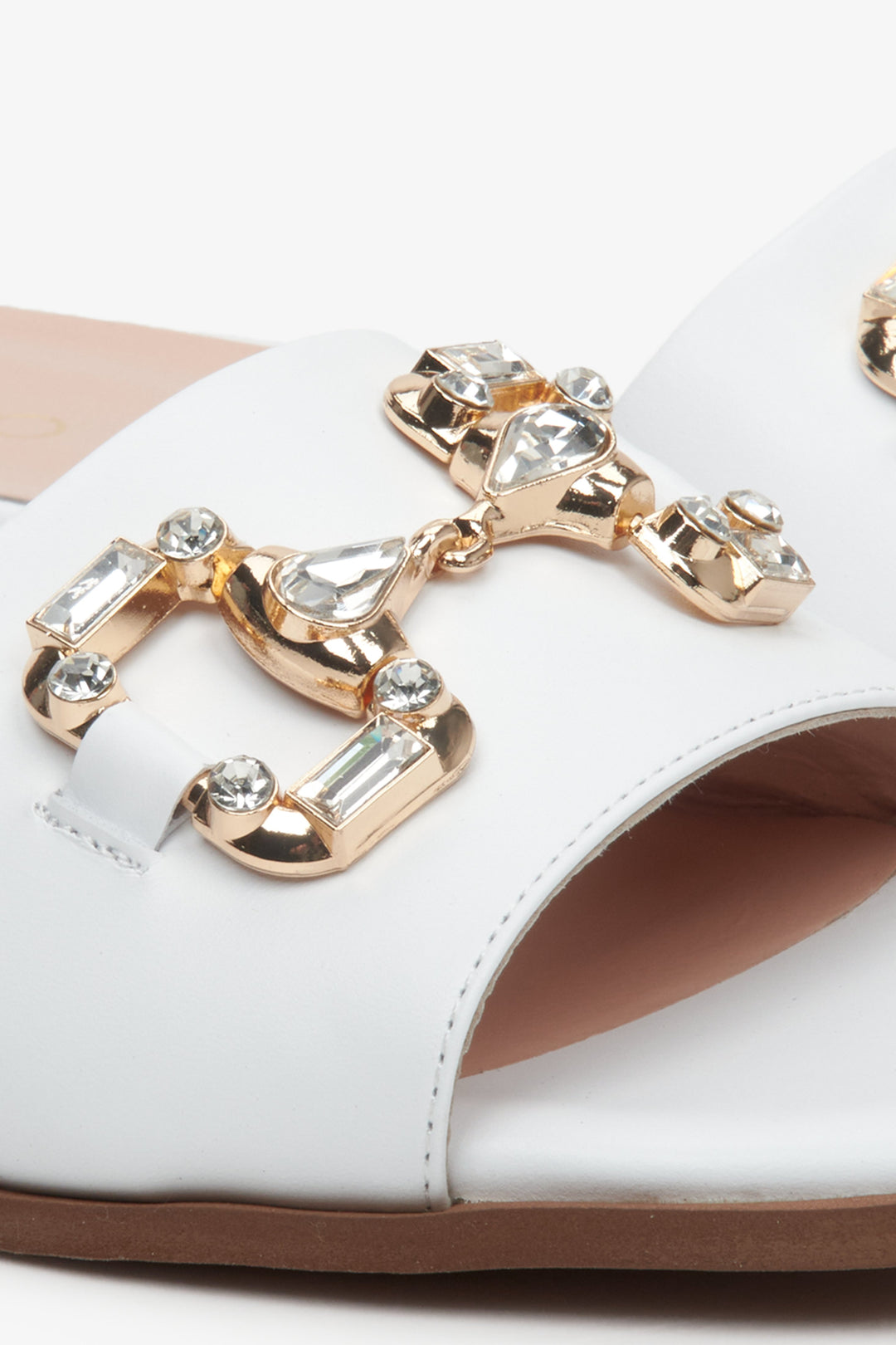 Women's white natural leather Estro flat slide sandals - close-up of gold application.