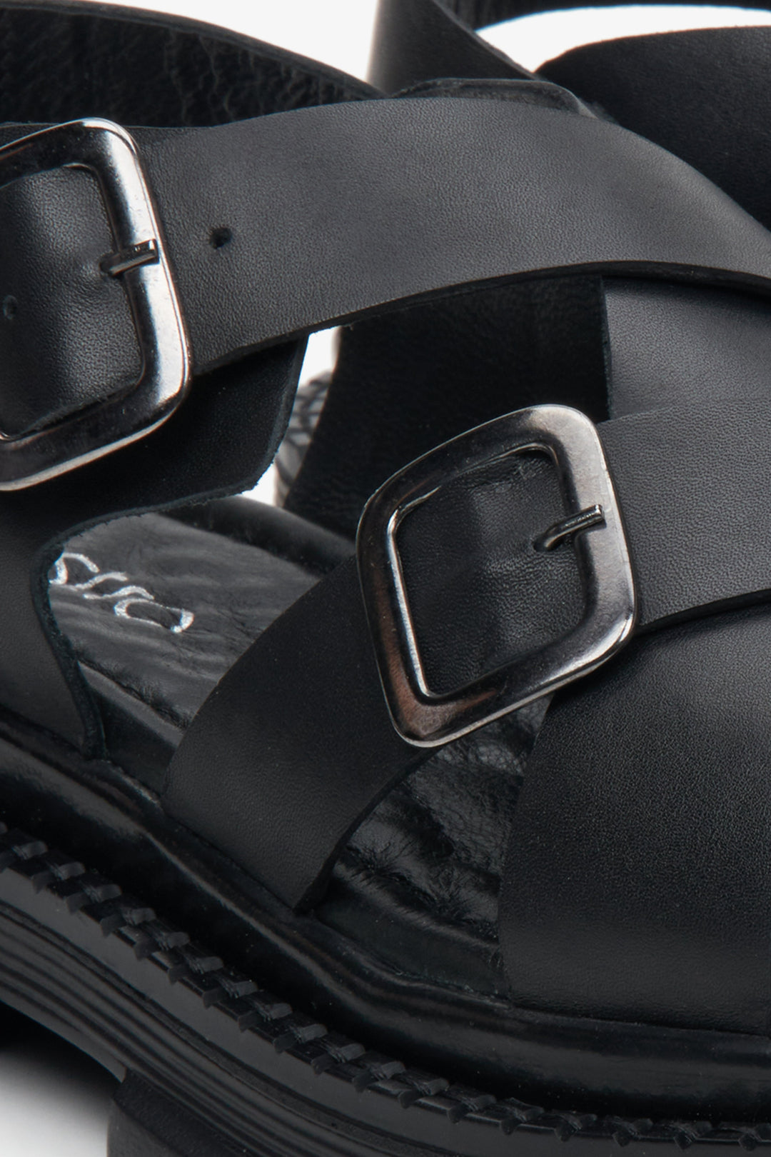 Women's black leather sandals - a close-up of the fastening and support system.