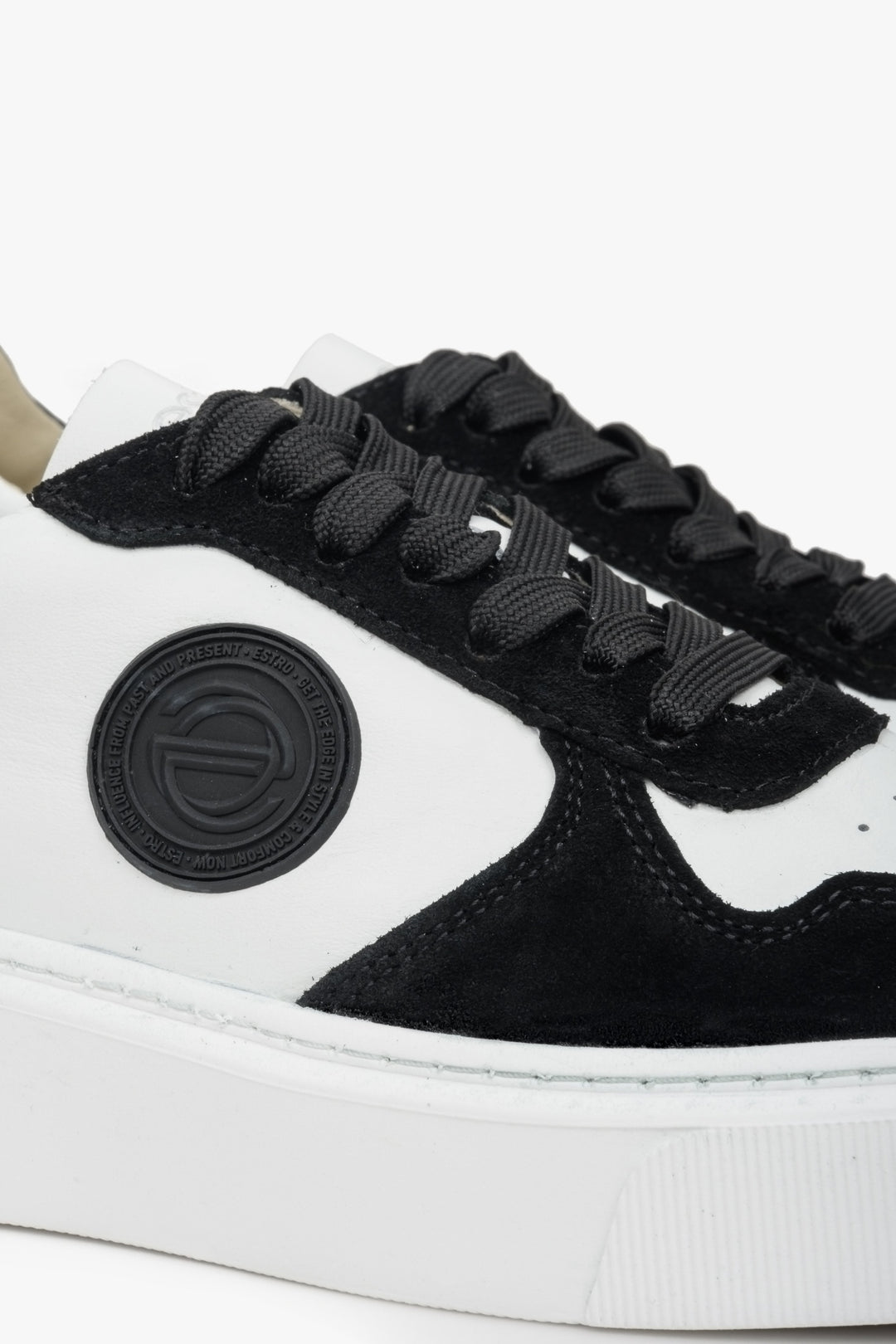 Estro velour and leather sneakers in white and black. Close-up of decorative logo.