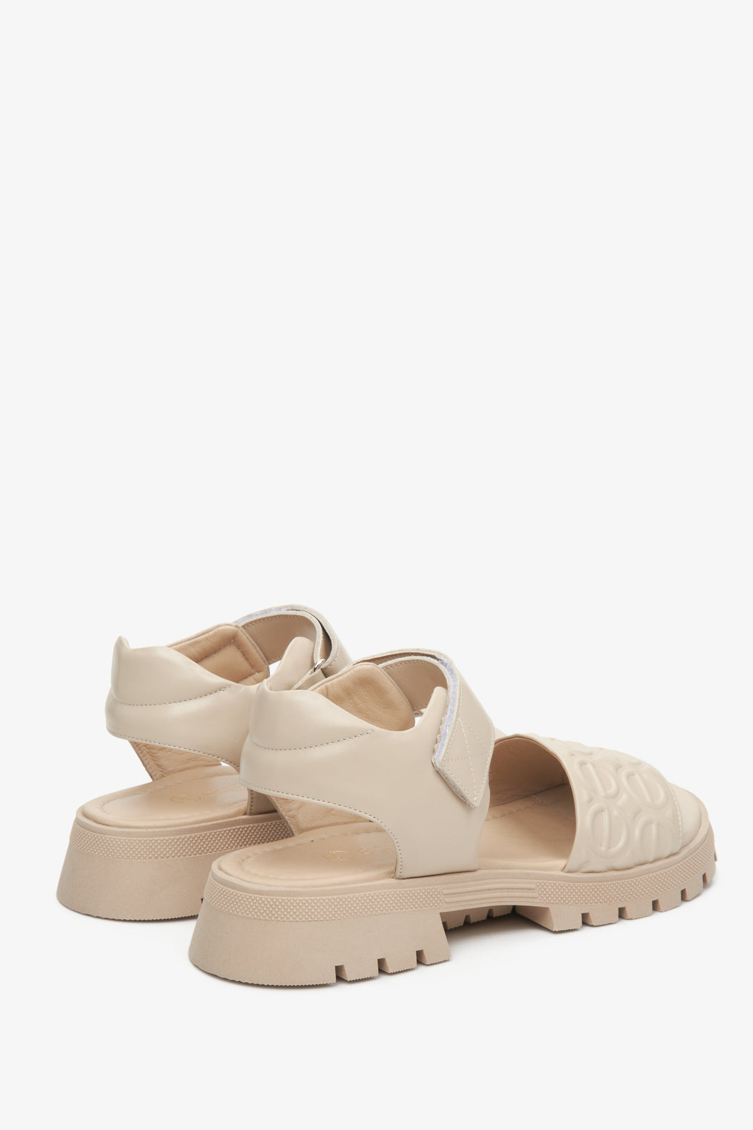 Beige leather Estro women's sandals on an elastic platform - close-up of the side line and back of the shoes.