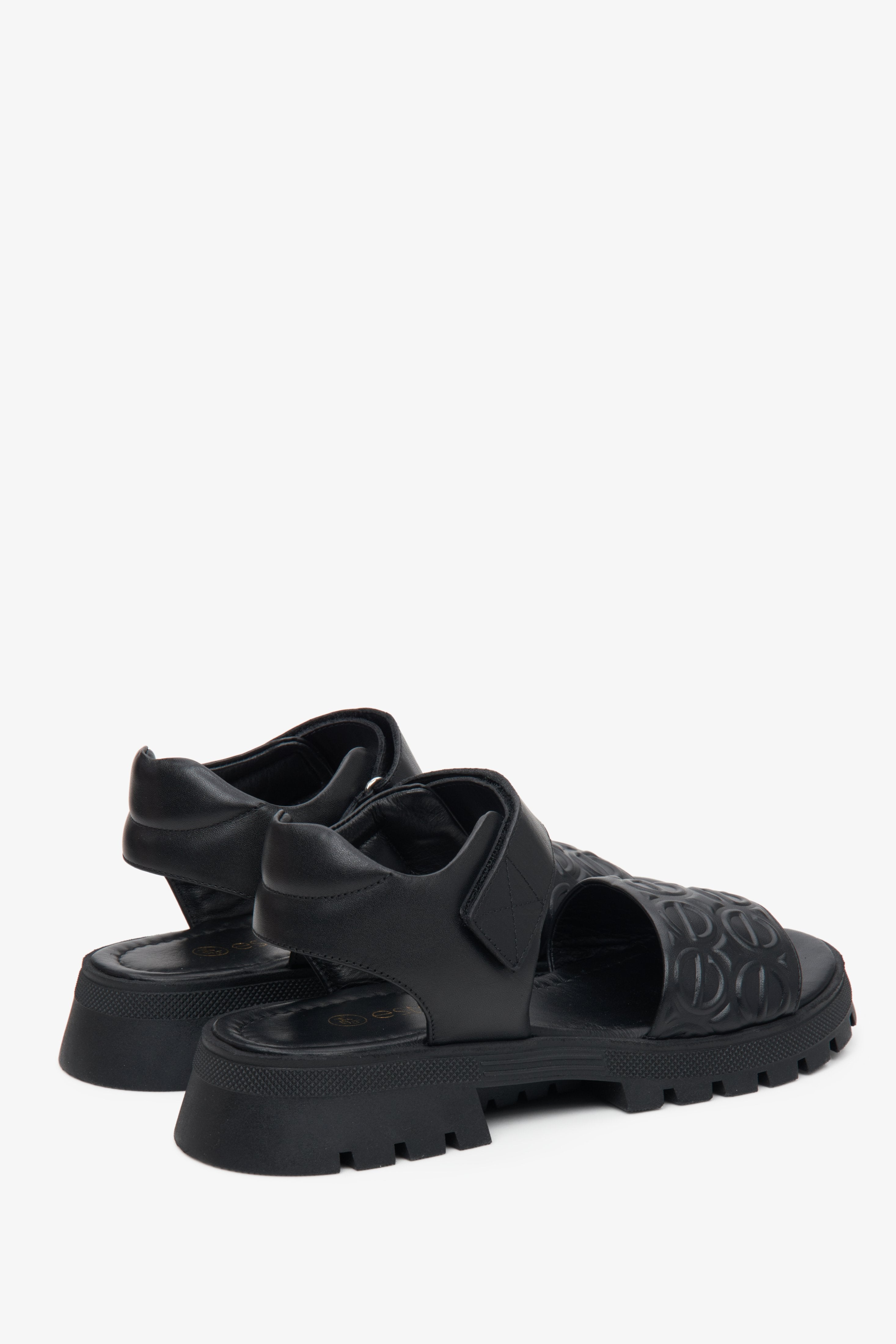 Black leather Estro women's sandals on an elastic platform - close-up of the side line and back of the shoes.