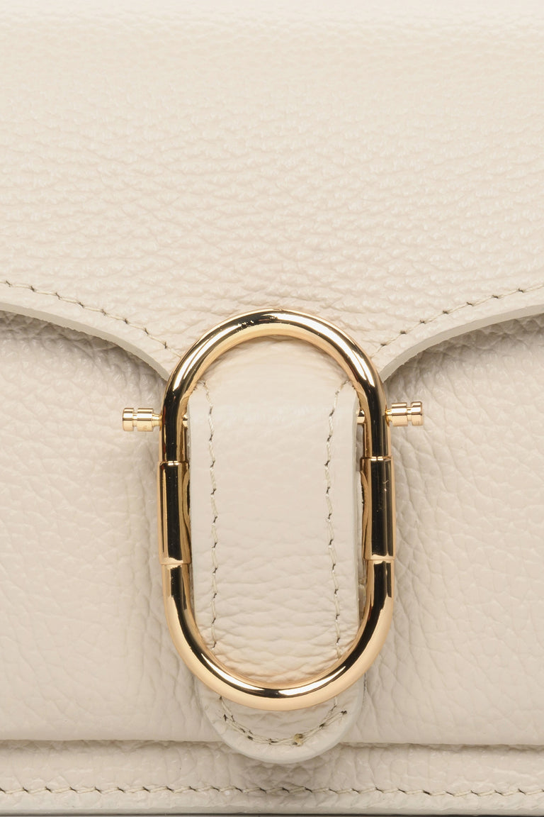 Small light beige women's handbag - close-up of gold application.