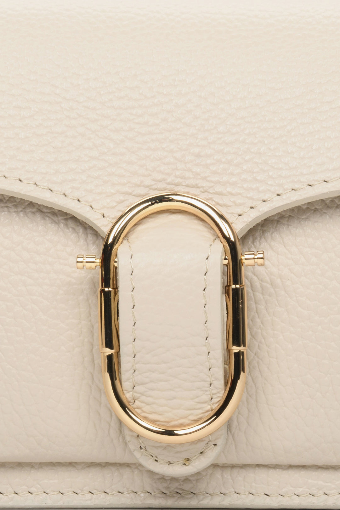 Small light beige women's handbag - close-up of gold application.