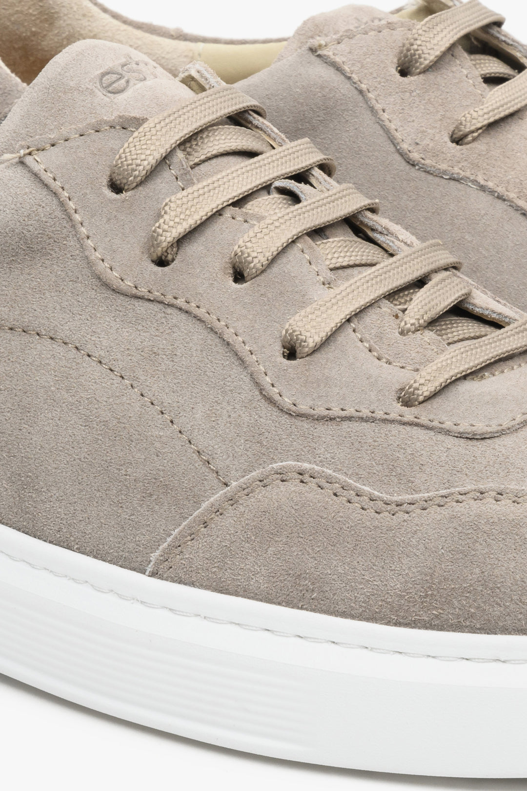 Grey velour men's sneakers with lacing - close-up of the stitching system.