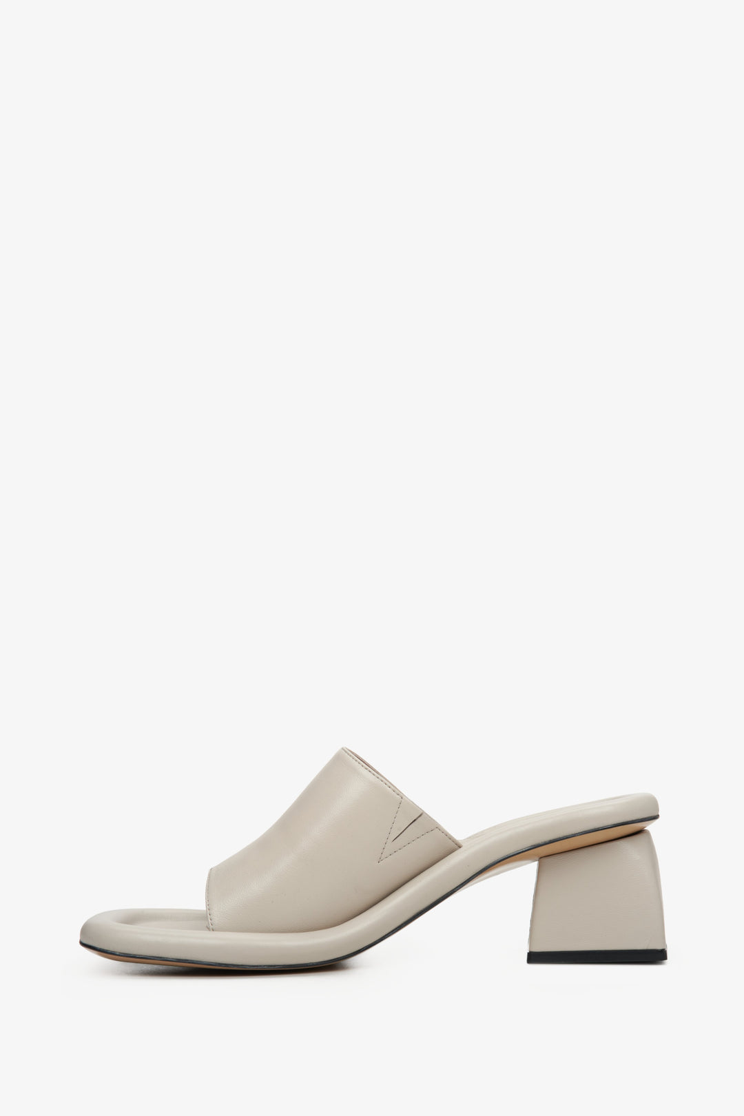 Stylish beige mules for women made of natural leather on a square heel - the profile of the shoes.